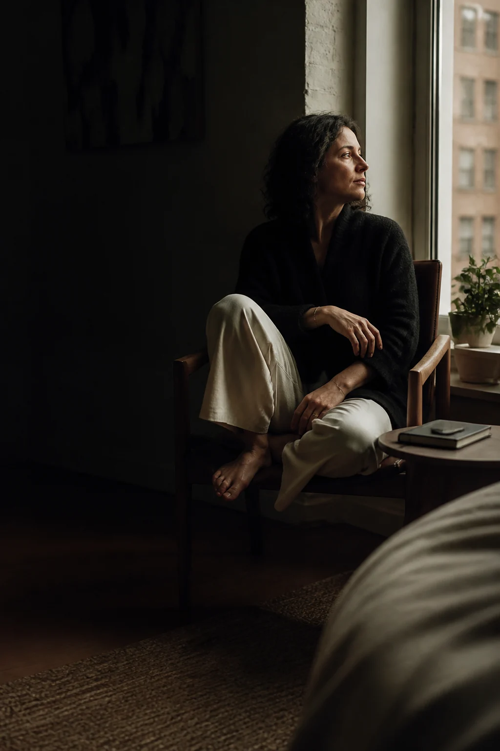 A person pausing beside a window in a quiet moment of reflection